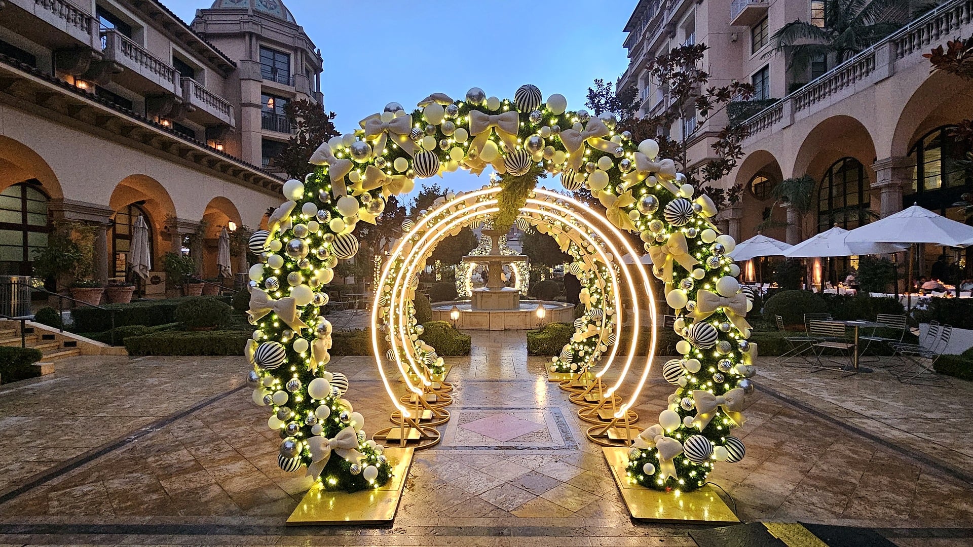 Illuminated holiday light arches over the fountain walk at Beverly Cañon Gardens in Beverly Hills