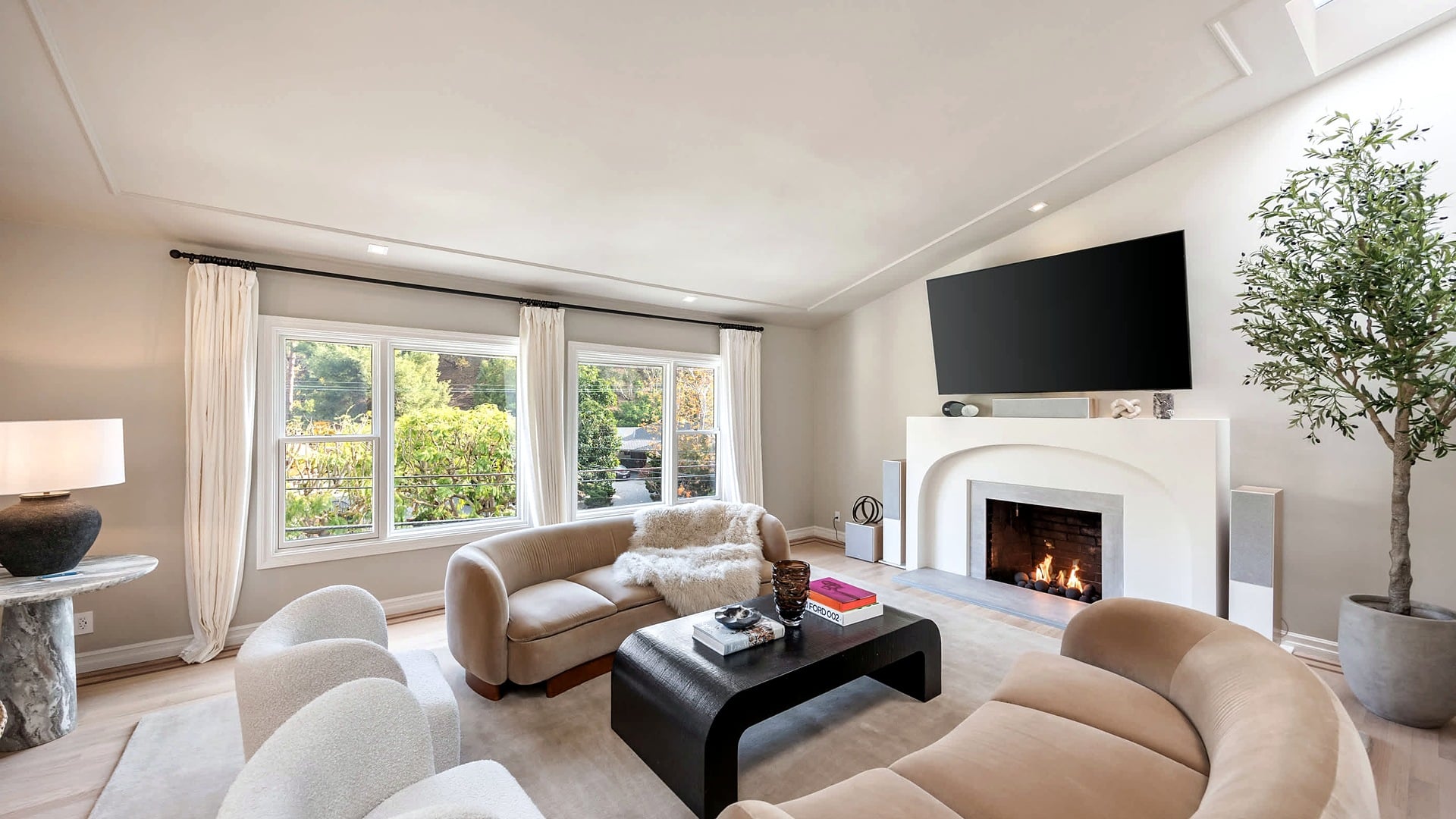 A fire glowing in the living room fireplace at Villa Avra, a Stay Awhile home in Beverly Hills